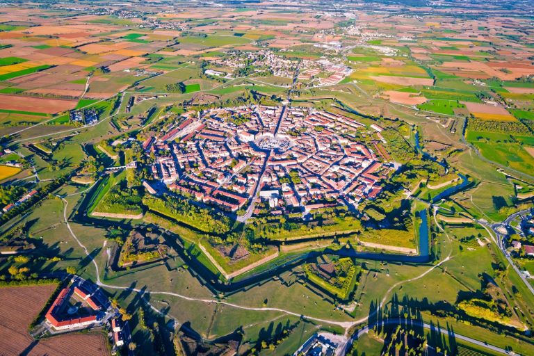 Palmanova. A nonagon formed by arrowhead bulwarks. And, added later, by nine bastions and nine lunettes surrounded by a dry moat.